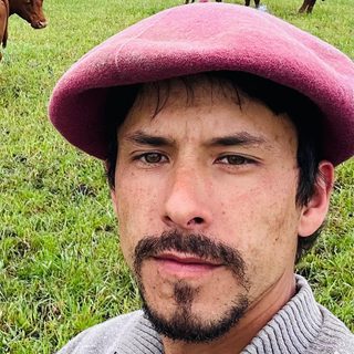 Gerson Duarte, capataz de fazenda, de boina no pasto com o gado atrás